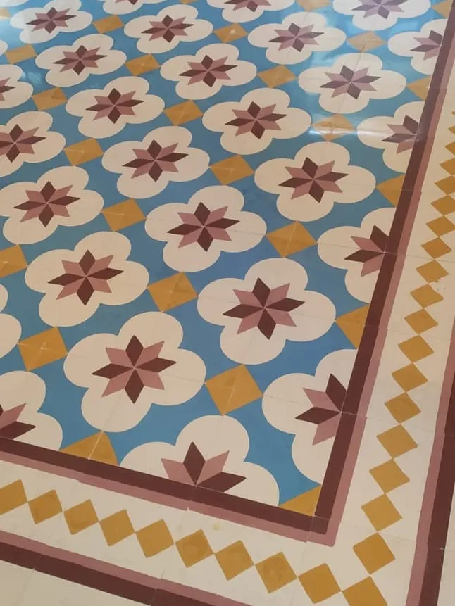 Blue, red and gold floral tiles framed by a patterned border