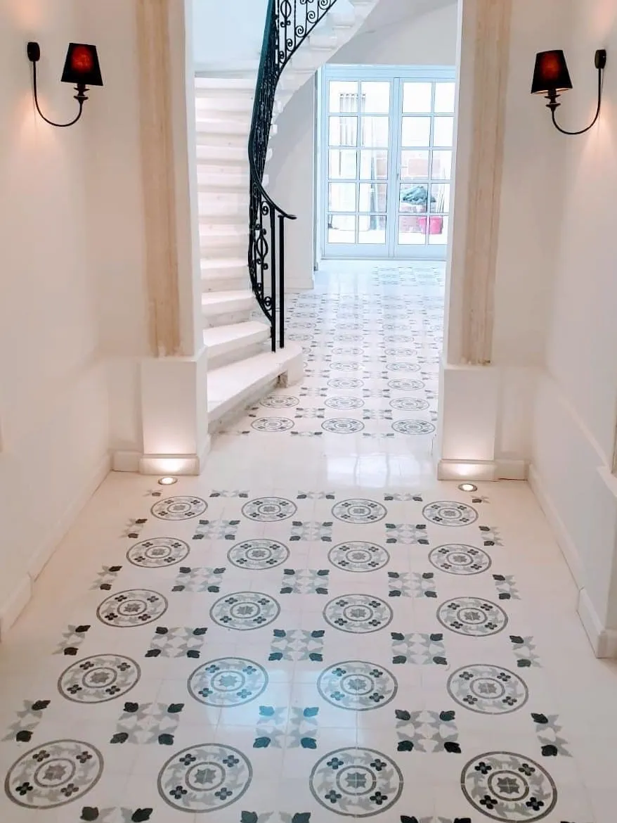 A long corridor laid with a patterned cement tile runner