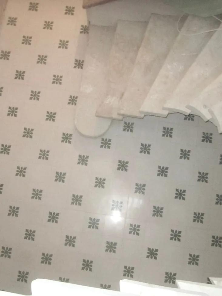 Grey star-patterned tiles running to the foot of a staircase