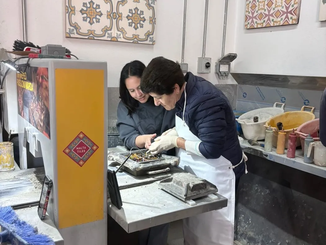 Visitors working at the benches inside the Malta Tiles workshop