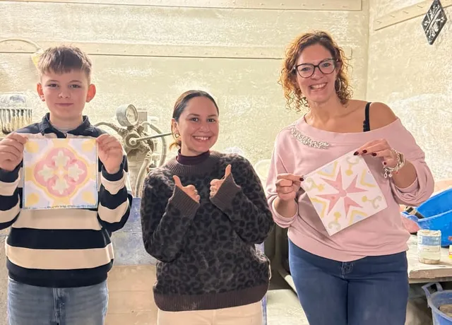 A family holding the tiles they made together