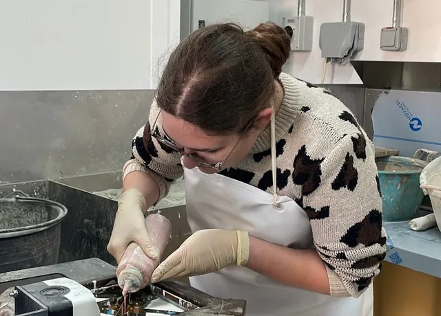 A participant carefully filling a tile mould